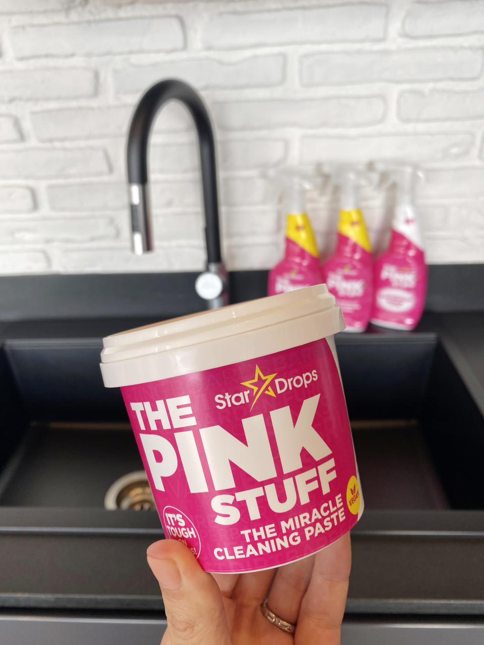 a tub of The Pink Stuff next to a sink