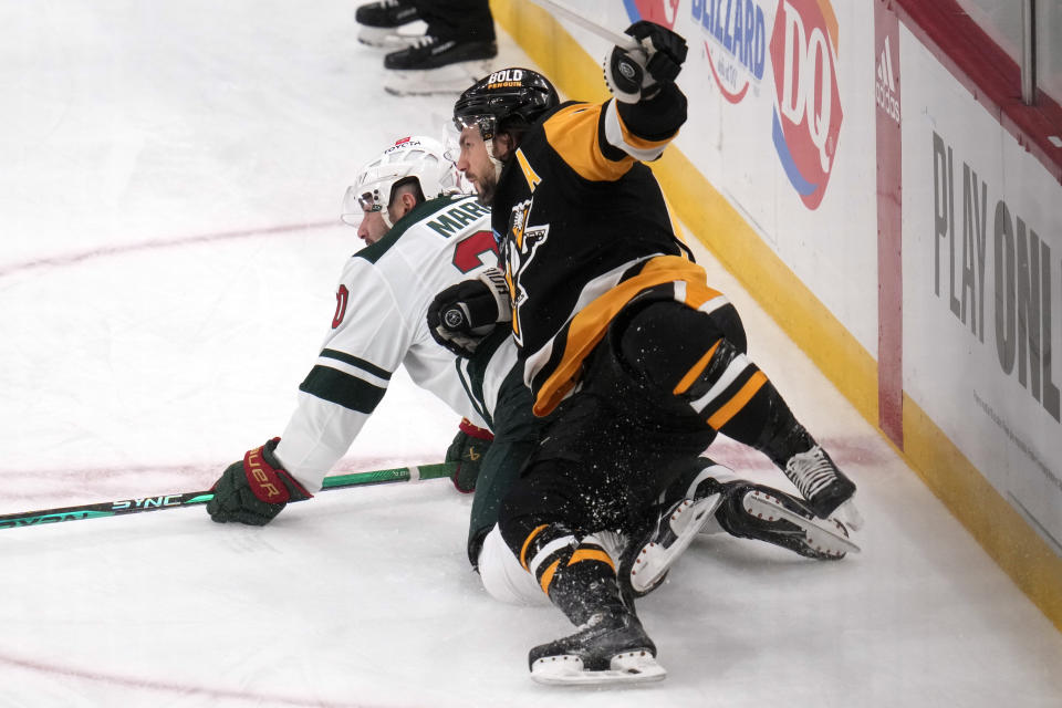 Pittsburgh Penguins' Kris Letang, top, collides with Minnesota Wild's Pat Maroon during the first period of an NHL hockey game in Pittsburgh, Monday, Dec. 18, 2023. (AP Photo/Gene J. Puskar)