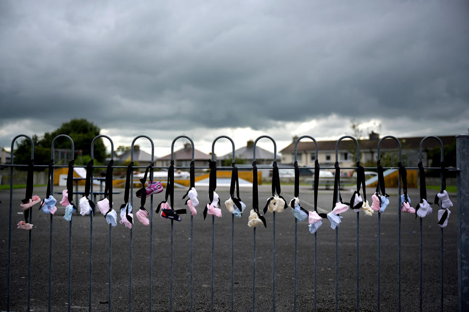 Image: Infant and baby shoes are hung along the playground fence as a vigil is held at the Tuam Mother and Baby home mass burial site (Charles McQuillan / Getty Images file)