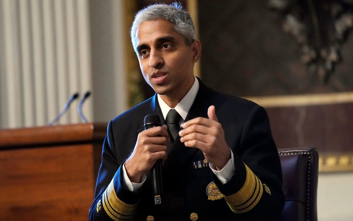 The surgeon general in his uniform, holding a microphone