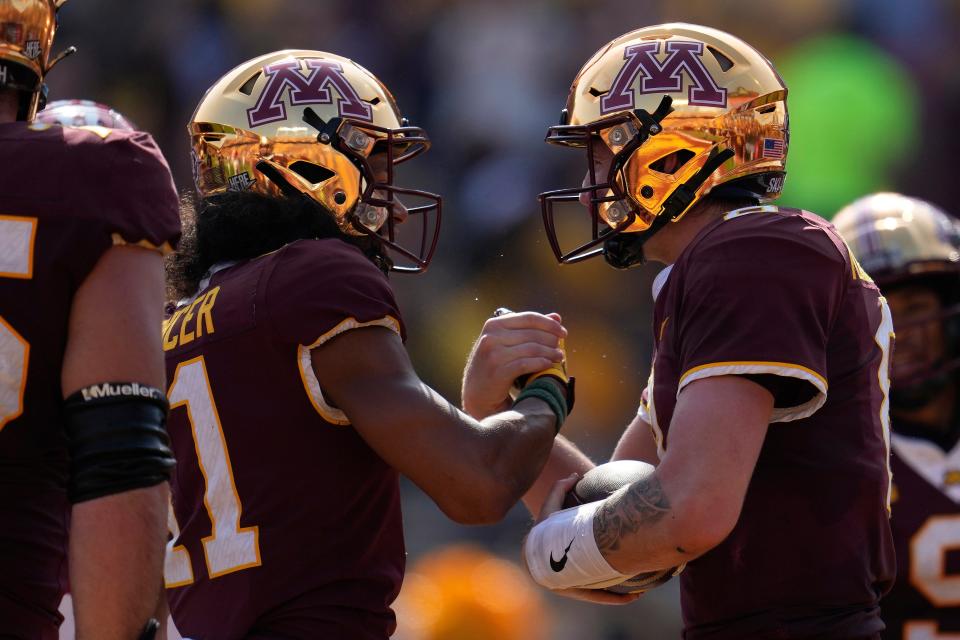 Minnesota quarterback Athan Kaliakmanis, right, celebrates with teammate wide receiver Elijah Spencer after running for a 10-yard touchdown during the first half of an NCAA college football game against Louisiana Lafayette, Saturday, Sept. 30, 2023, in Minneapolis. (AP Photo/Abbie Parr)
