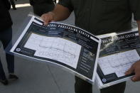 Border Patrol agents show reporters the floor plan of an immigration holding facility, Tuesday, Feb. 25, 2020, in El Paso, Texas. The complex of modular buildings can house and process 1,040 and will replace tents hastily erected for processing last spring. (AP Photo/Cedar Attanasio)