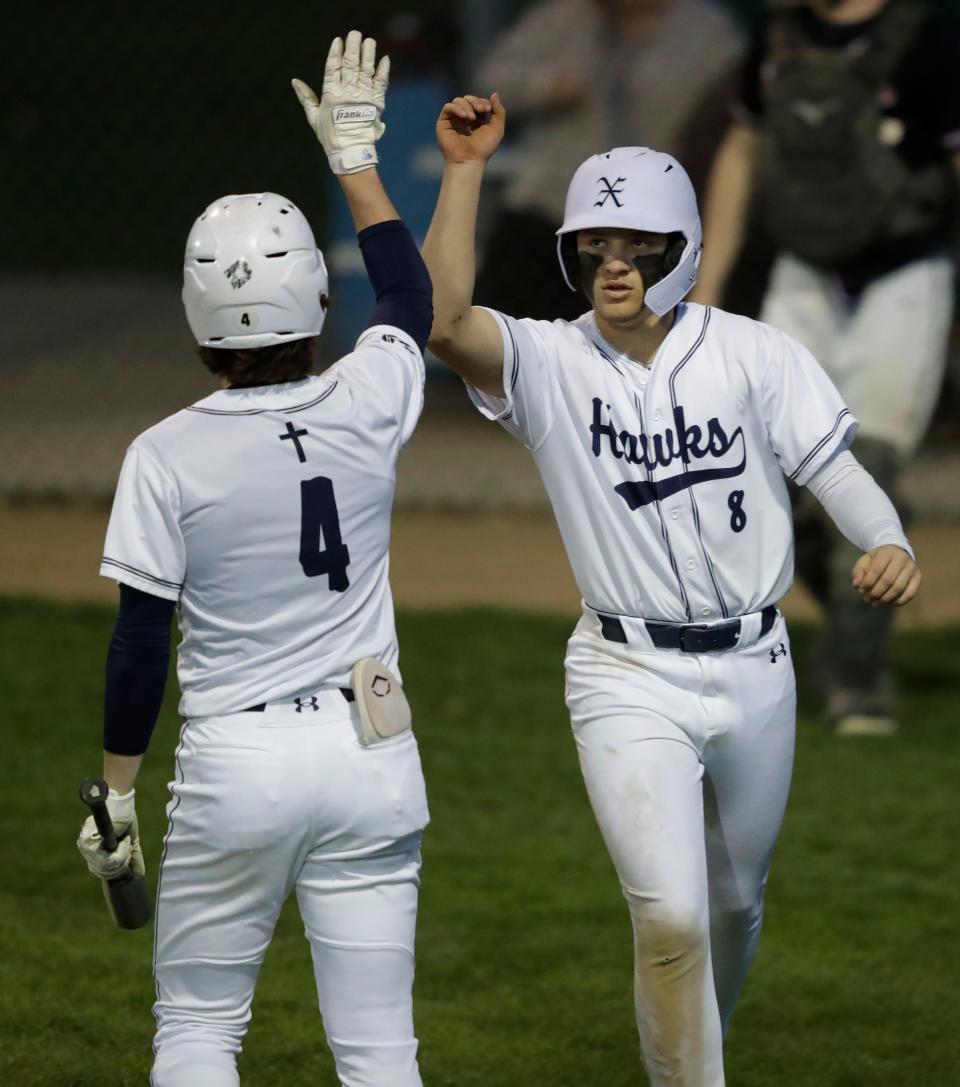 Xavier's Matthew Potter (8) celebrates scoring a run with Isaiah Des Jardins during a game against Shawano on Monday at Don Hawkins Field in Appleton.