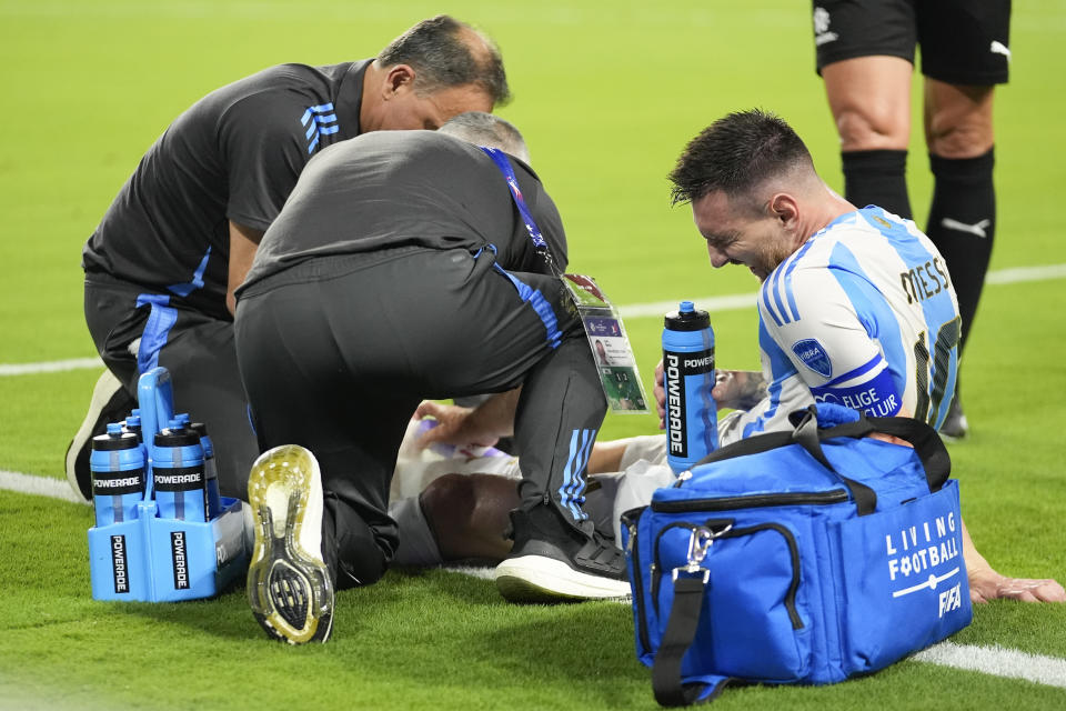 Argentina's Lionel Messi is assisted by medical staff during the Copa America final soccer match against Colombia in Miami Gardens, Fla., Sunday, July 14, 2024. (AP Photo/Rebecca Blackwell)