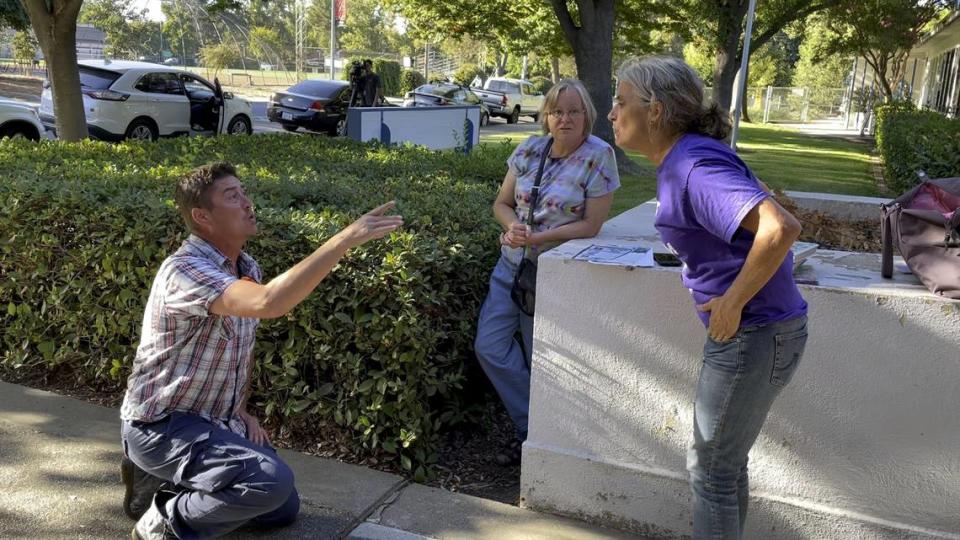 Liam Taylor, left, argues with Yolo County Moms for Liberty chapter chair Beth Bourne outside a closed-door meeting at the Davis Joint Unified School District offices in September, as board members met behind closed doors with police over a series of bomb threats that had disrupted schools since August.