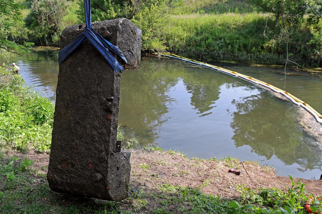 Crews pulled out an old saddle fuel tank from the Tuscarawas River on Wednesday during cleanup after an oil spill earlier this month, in Barberton.