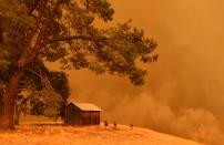 <p>Firefighters watch as flames from the County Fire climb a hillside in Guinda, Calif. on July 1, 2018. (Photo: Josh Edelson/AFP/Getty Images) </p>