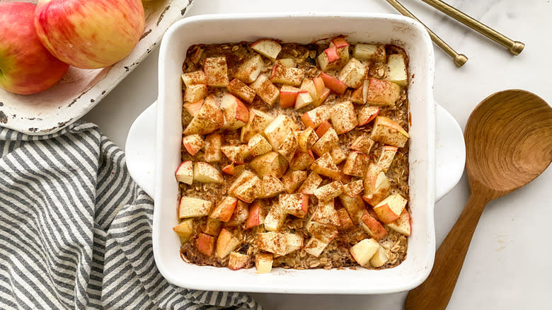 baked oatmeal in pan next to wooden spoon