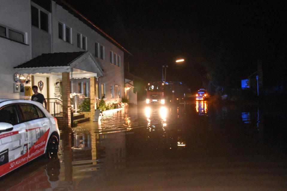 Cars park at a flooded road in Kopfsberg, Germany, Thursday, June 24, 2021. Thunderstorms and heavy rainfall caused flooded streets, full cellars and fallen trees in Lower Bavaria on Thursday night. (Seidl/dpa via AP)