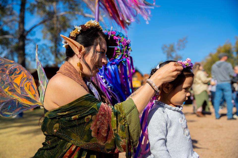 Alexandria Harris (left) places a flower crown on Iliana Mundo (right) at the Renaissance Festival in Gold Canyon on Feb. 18, 2023.