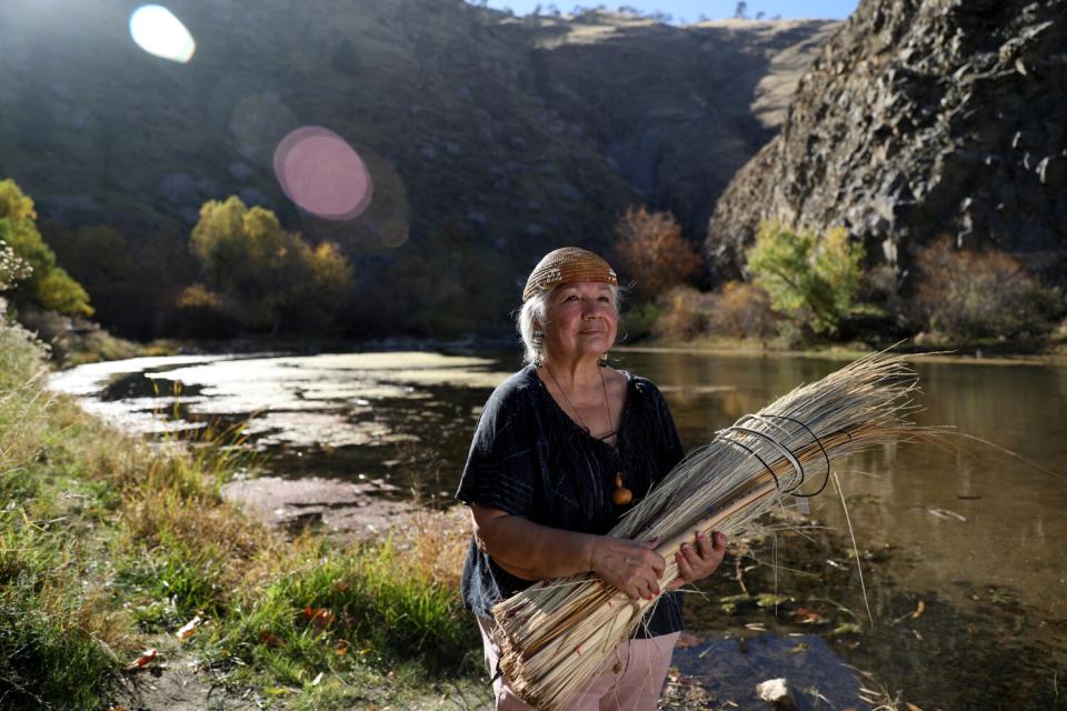 Delia "Dee" Dominguez wears a basket cap she weaved from deer grass and juncus reeds