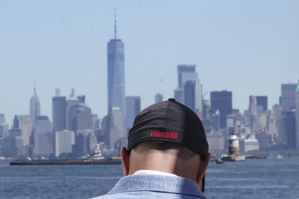 Eddie Bracken wears a cap with the word "freedom" while preparing for an interview at the Staten Island September 11th Memorial, in view of lower Manhattan, Friday Sept. 2, 2022, in New York. Bracken, a carpenter whose sister Lucy Fishman was killed in the Sept. 11 attacks on the World Trade Center, is awaiting the trial of the attack's self-professed architect Khalid Sheik Mohammed and his co-defendants at Guantanamo. (AP Photo/Bebeto Matthews)