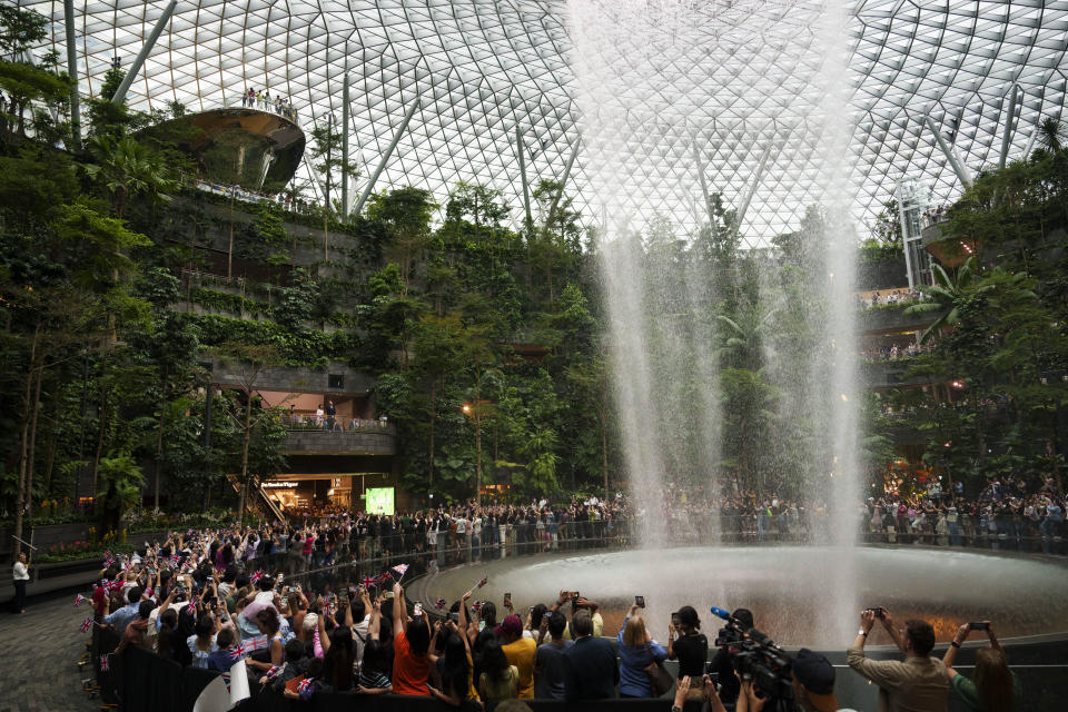 Britain's Prince William, left, stops at the rain vortex waterfall at Jewel Changi airport, Singapore, Sunday, Nov. 5, 2023. (AP Photo/Vincent Thian)