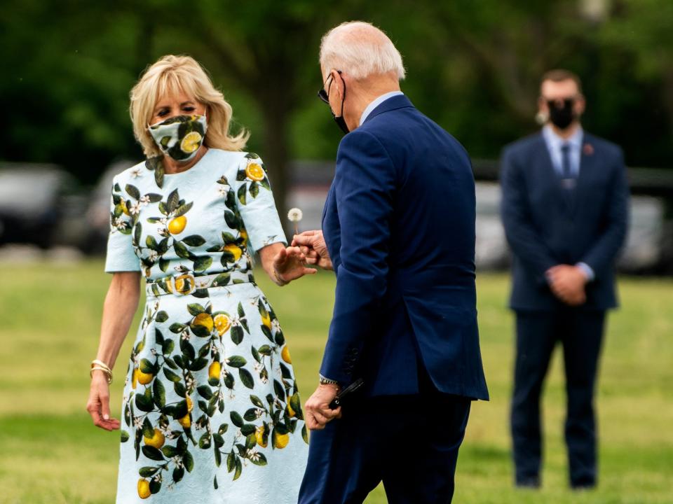 President Joe Biden hands Dr. Jill Biden a dandelion.