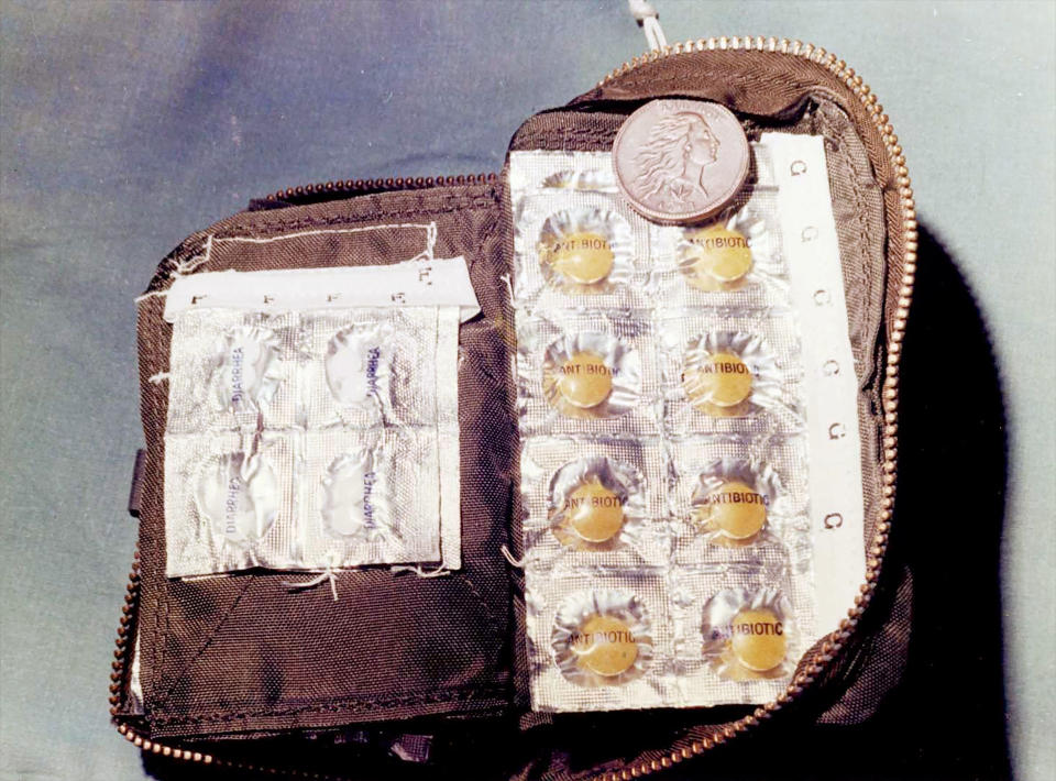 close-up of an open brown leather bag containing eight tokens in a silver case