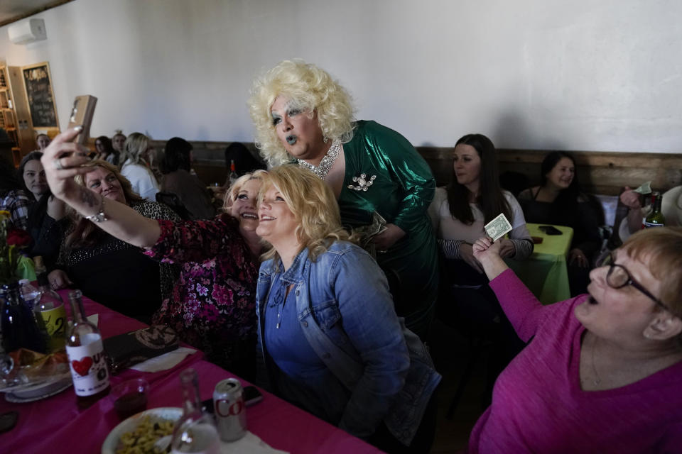 Drag queen Alexus Daniels, dressed as Dolly Parton, poses for selfie photos with audience members as she performs at "Spring Fever Drag Brunch," Sunday, March 26, 2023, at the Kulpmont Winery in Kulpmont, Pa. (AP Photo/Carolyn Kaster)