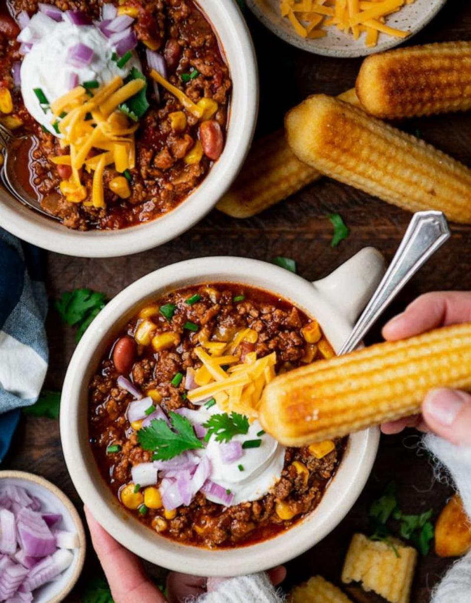 PHOTO: Bowls of beef chili topped with sour cream, red onions and shredded cheese. (The Seasoned Mom)