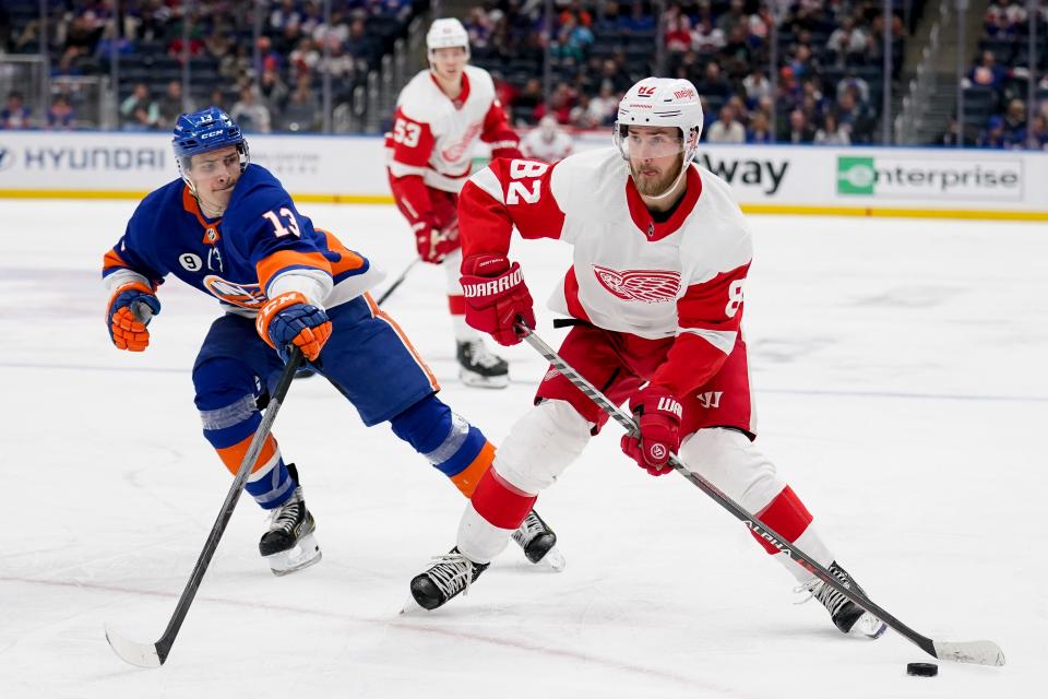 Detroit Red Wings defenseman Jordan Oesterle (82) sets up a pass against New York Islanders center Mathew Barzal (13) in the third period of an NHL hockey game, Thursday, March 24, 2022, in Elmont, N.Y.