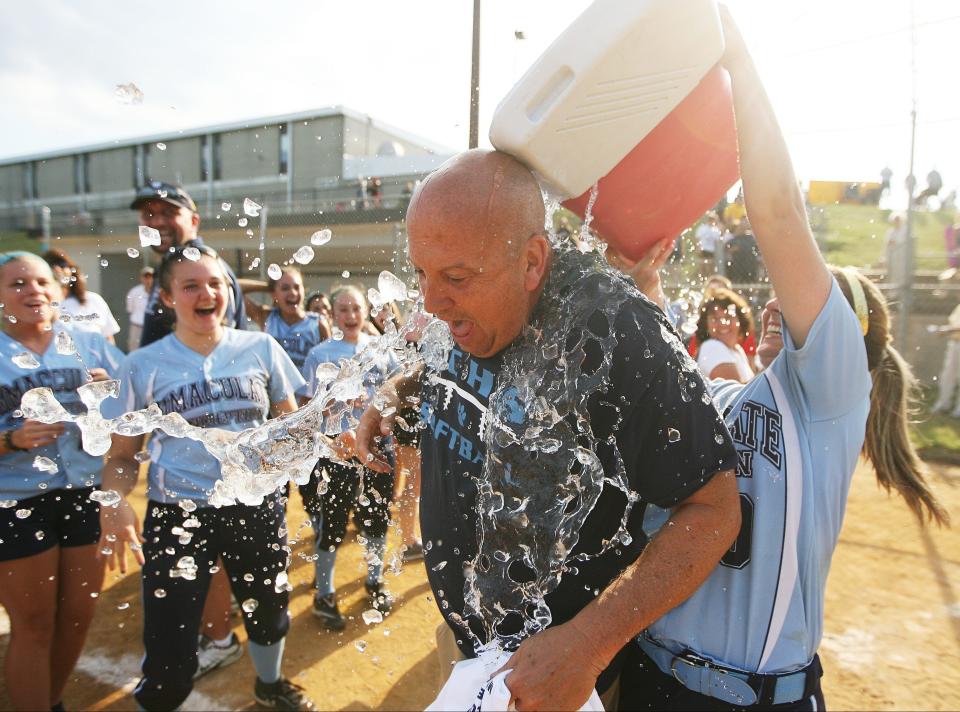 Immaculate Conception head coach Jeff Horohonich is showered with cold water by his players after his team won the softball championship over Sacred Heart in 2013.