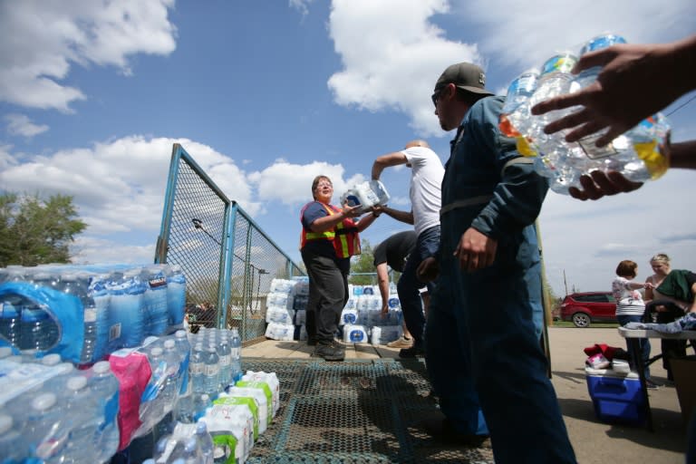 Volunteers load donated flats of water to be taken to a camp just outside of Wandering River, Canada on May 5, 2016