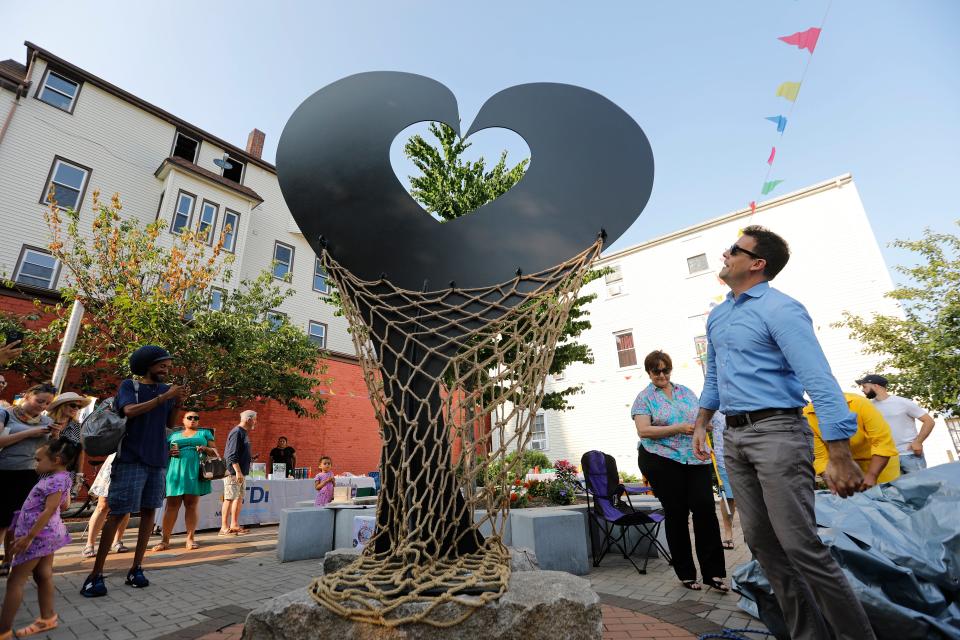 Representative Chris Hendricks looks at the Love the Ave "Love Locks" sculpture after he unveiled it at the Nye Street Pocket Park at the intersection of Acushnet Avenue and Nye Street in New Bedford.