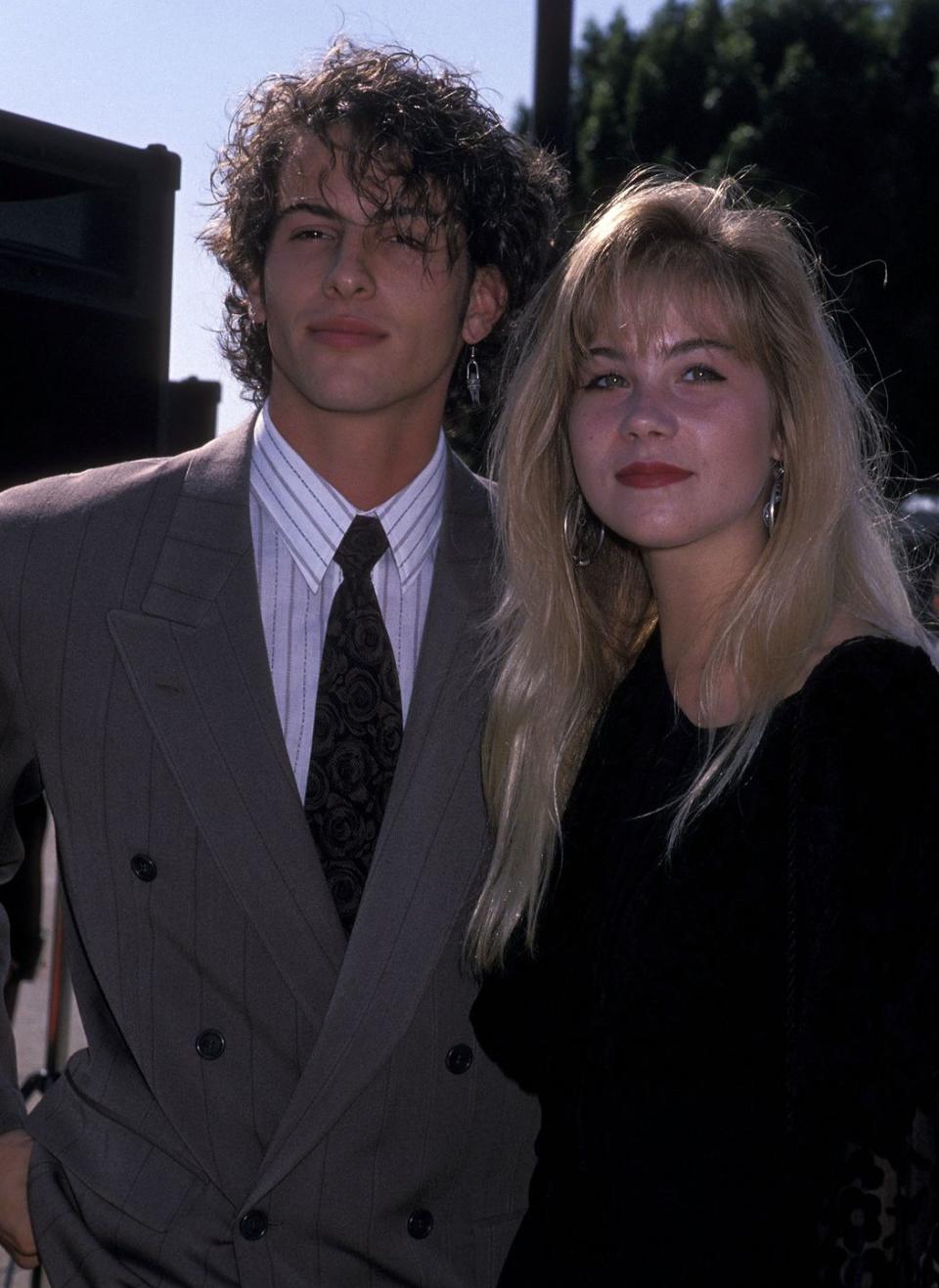 <p>Young 80s Hollywood made a swift and memorable appearance with this couple—complete with pinstripes and big hair.</p>