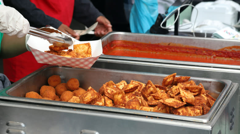 chef putting toasted ravioli in a dish