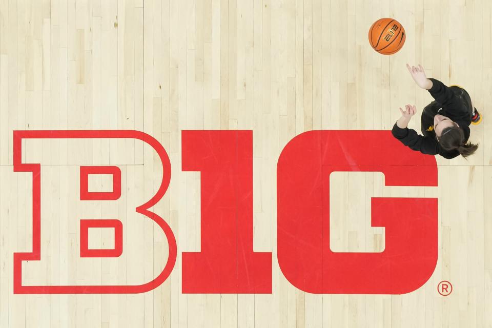 Iowa guard Caitlin Clark warms up over the Big Ten Conference logo at Ohio State's at Value City Arena.