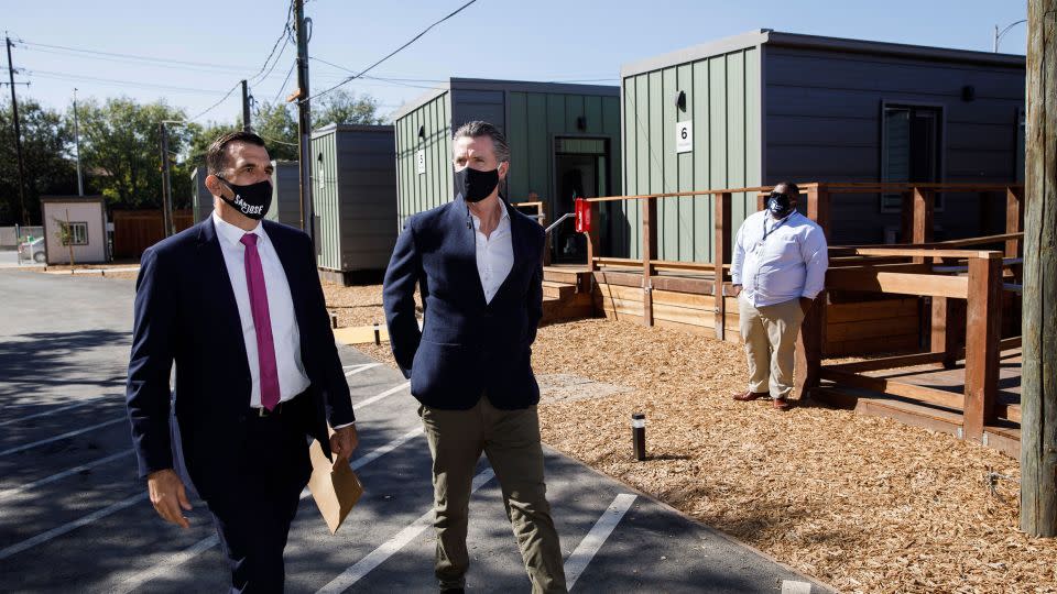 California Gov. Gavin Newsom, center, and San Jose Mayor Sam Liccardo, left, tour an emergency housing community site in San Jose in October 2020, shortly after Newsom announced more funding to fight homelessness. - Dai Sugano/Bay Area News Group/AP