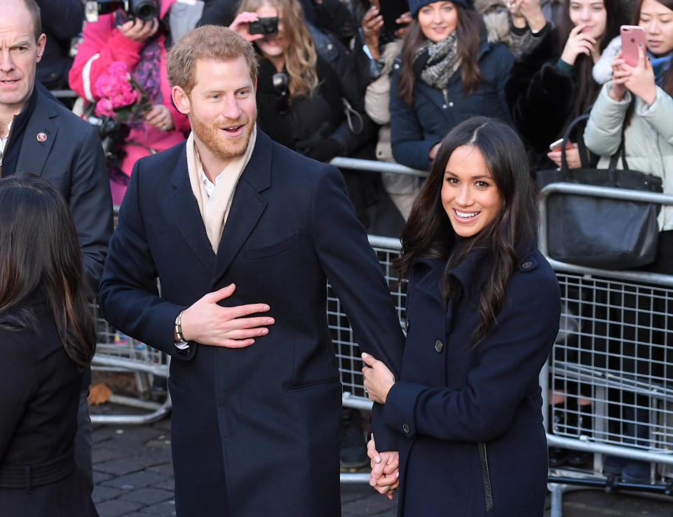 Meghan Markle grabs hold of Prince Harry's arm as they attend a royal visit