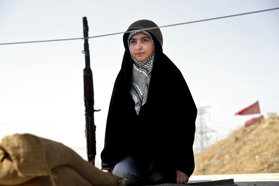 In this Thursday, Aug. 22, 2013 photo, a female member of the Basij paramilitary militia sits near her a rifle during a training session, in Tehran, Iran. Basij branches can be found in all governmental bodies, universities and schools. Volunteers often enjoy favorable treatment from the government, particularly in securing jobs in the public sector. (AP Photo/Ebrahim Noroozi)