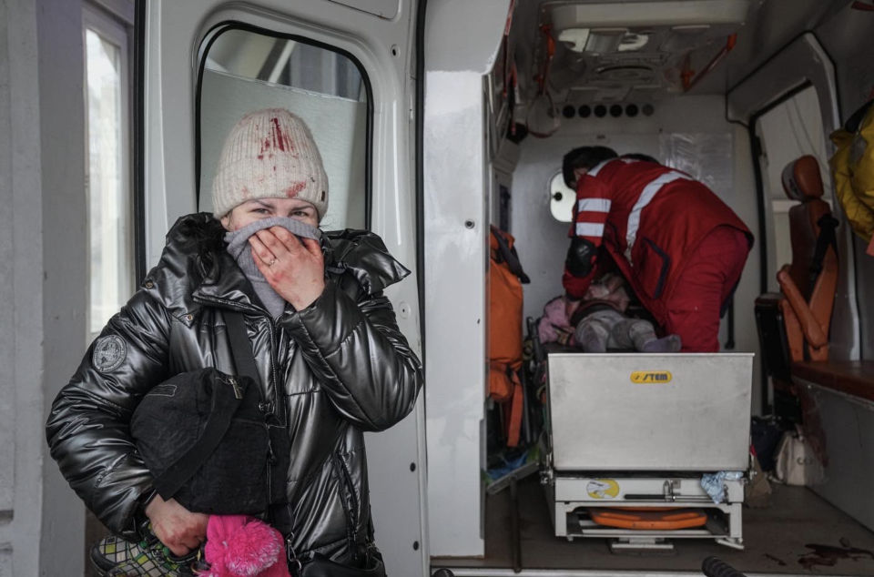 A woman reacts as paramedics perform CPR on a girl who was injured during shelling, at city hospital of Mariupol, eastern Ukraine, Sunday