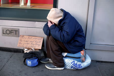 A homeless man sits bundled against the cold as he begs for handouts on West 42nd Street in the Manhattan borough of New York City, January 4, 2016. REUTERS/Mike Segar