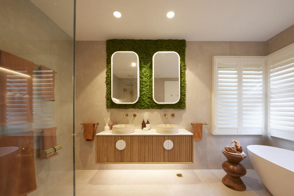 Wide shot of the bathroom, the moss wall over the vanity, bath to the right. 
