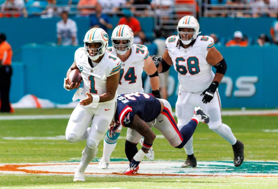 Miami Dolphins quarterback Tua Tagovailoa (1) scrambles for yardage as New England Patriots linebacker Mack Wilson Sr. (3) during second quarter of an NFL football game at Hard Rock Stadium on Sunday, Oct. 29, 2023 in Miami Gardens, Fl.