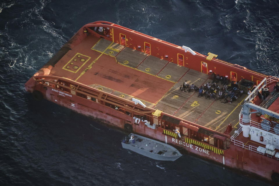 Migrants sit on the deck of the Italian supply vessel Asso Ventinove after they were rescued from an unseaworthy boat drifting in the Mediterranean Sea near the Bouri oilfields north of Libya, Saturday, Oct. 2, 2021, as seen from aboard the humanitarian aircraft Seabird. The offshore supply vessel rescued dozens of migrants, including women and children, fleeing Libya to Europe on a crowded, wooden boat. (AP Photo/Renata Brito)