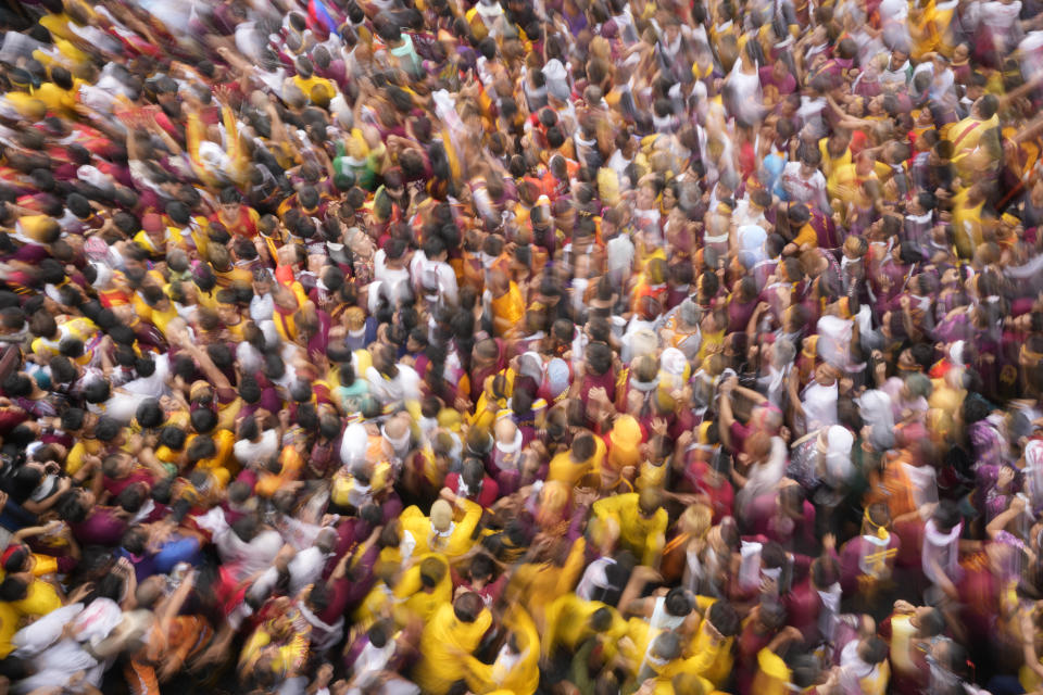 Devotees join the annual Black Nazarene procession which was resumed after a three-year suspension due to the coronavirus pandemic on Tuesday, Jan. 9, 2024 in Manila, Philippines. A mammoth crowd of mostly barefoot Catholic devotees joined a chaotic procession through downtown Manila Tuesday to venerate a centuries-old black statue of Jesus Christ with many praying for peace in the Middle East where Filipino relatives work. (AP Photo/Aaron Favila)