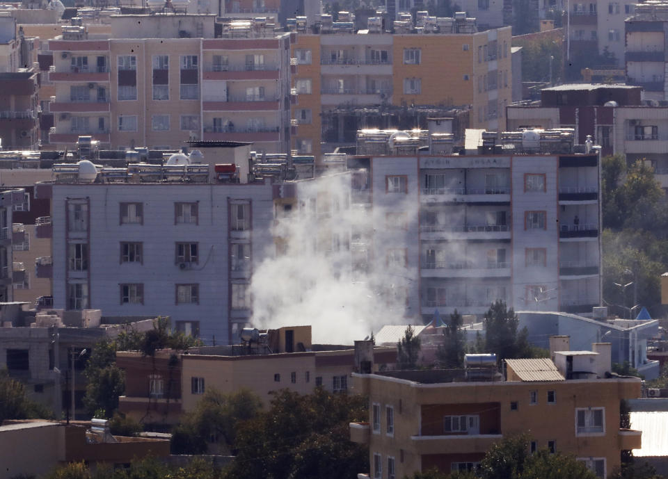 In this photo taken from the Turkish side of the border between Turkey and Syria, in Ceylanpinar, Sanliurfa province, southeastern Turkey, smoke billows from targets in Ras al-Ayn, Syria, caused by shelling by Turkish forces, Friday, Oct. 18, 2019. Fighting continued in a northeast Syrian border town at the center of the fight between Turkey and Kurdish forces early Friday, despite a U.S.-brokered cease-fire that went into effect overnight. Shelling and gunfire could be heard in and around Ras al-Ayn, as smoke billowed from locations near the border with Turkey and the Turkish town of Ceylanpinar. (AP Photo/Lefteris Pitarakis)