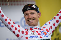 Denmark's Magnus Cort Nielsen, wearing the best climber's dotted jersey, celebrates on the podium after the third stage of the Tour de France cycling race over 182 kilometers (113 miles) with start in Vejle and finish in Sonderborg, Denmark, Sunday, July 3, 2022. (AP Photo/Daniel Cole)