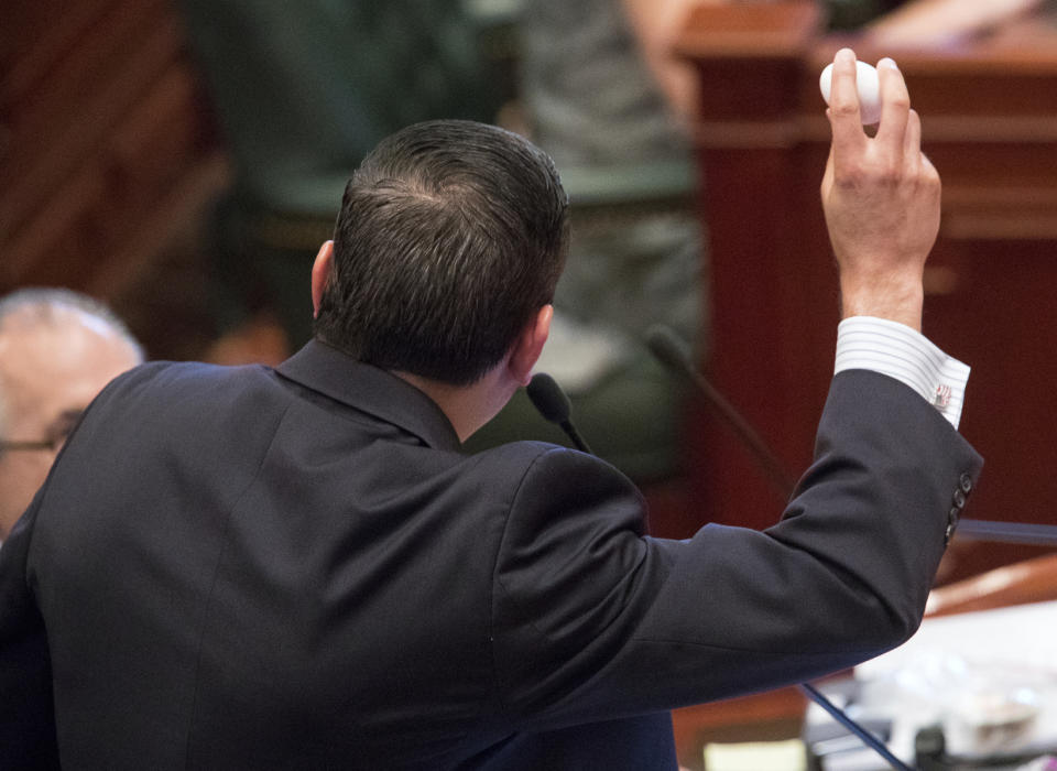 Illinois state Rep. Anthony DeLuca, D-Chicago Heights, holds up an egg before cracking it into a pan to reference the "This is your brain on drugs," campaign during debate on a bill to legalize recreational marijuana use in the Illinois House chambers Friday, May 31, 2019. DeLuca voted against the bill that passed the House 66-47. (Ted Schurter/The State Journal-Register via AP)