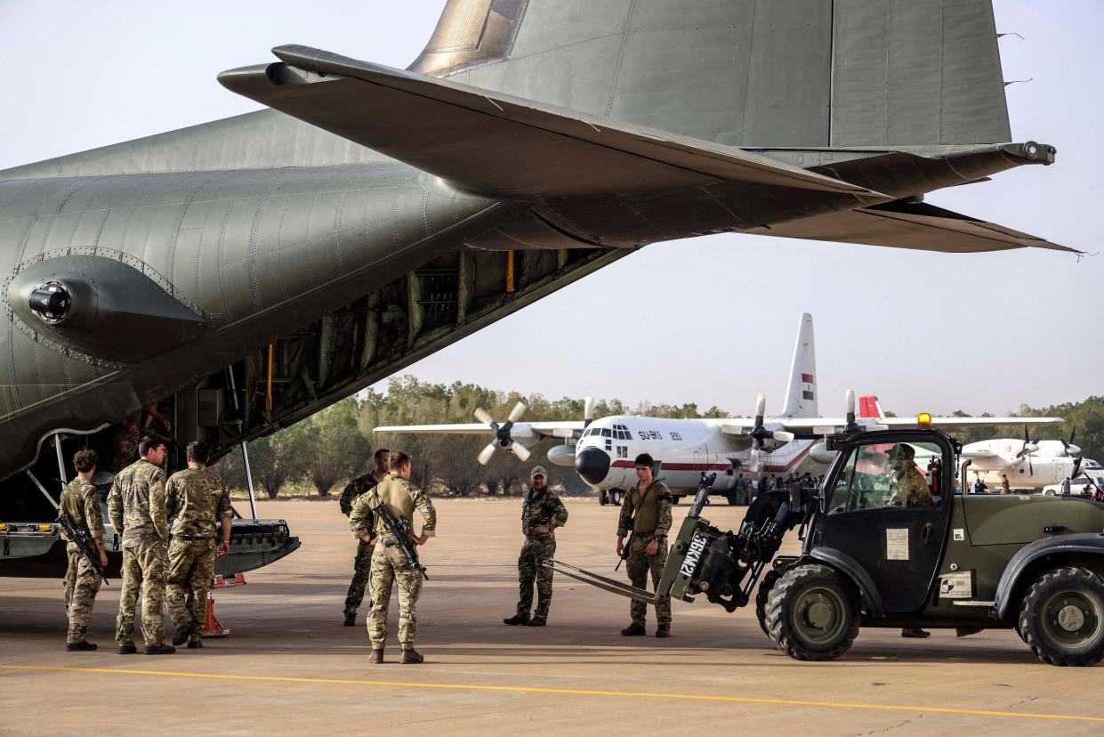 Military personnel unload stores during the evacuation of British citizens, at Wadi Seidna airport (via REUTERS)