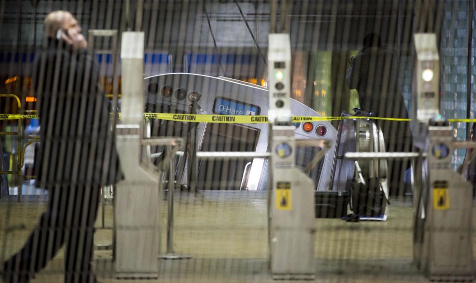 FILE - In this Monday, March 24, 2014 file photo, a Chicago Transit Authority train car rests on an escalator at the O'Hare Airport station after it derailed, injuring more than 30 people, in Chicago. Had the crash occurred during the day, when the trains are often full and the escalator packed with luggage-carrying travelers, far more people likely would have been injured, some even killed, said Joseph Schwieterman, a transportation expert at DePaul University. (AP Photo/Andrew A. Nelles, File)