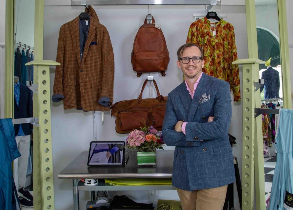 Andrew Oman, store manager for Maxwell &amp; Co., stands in front of a collection of Brunello Cucinelli handbags and Dries Van Noten pieces for men and women. Maxwell &amp; Co., a 39-year-old, family-owned clothing store based in Cape Cod, opened a seasonal location in Palm Beach this month.