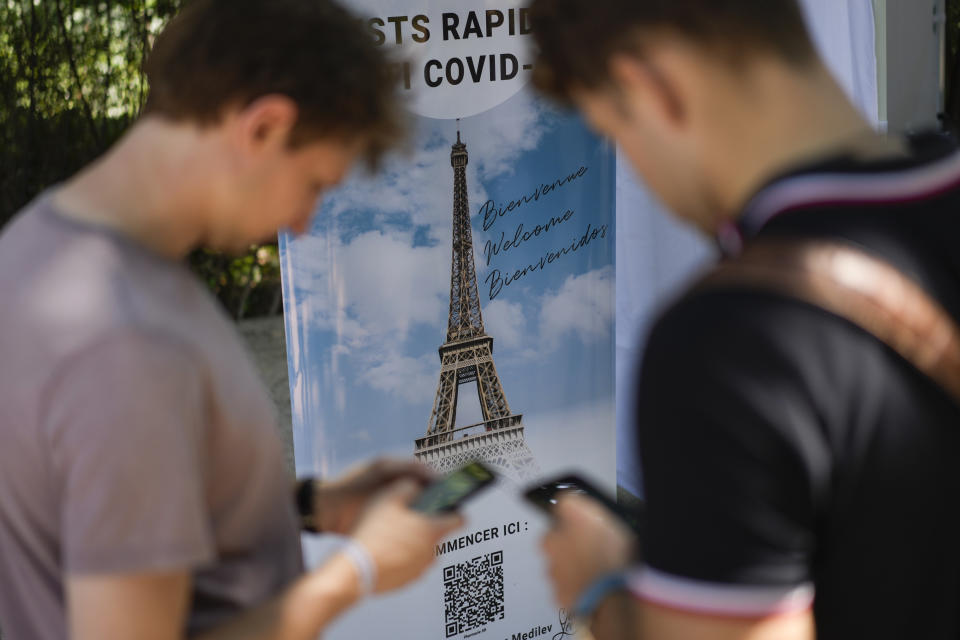 Visitors register for COVID-19 tests at the Eiffel Tower in Paris, Wednesday, July 21, 2021. Visitors now need a special COVID pass to ride up the Eiffel Tower or visit French museums or movie theaters, the first step in a new campaign against what the government calls a "stratospheric" rise in delta variant infections. (AP Photo/Daniel Cole)