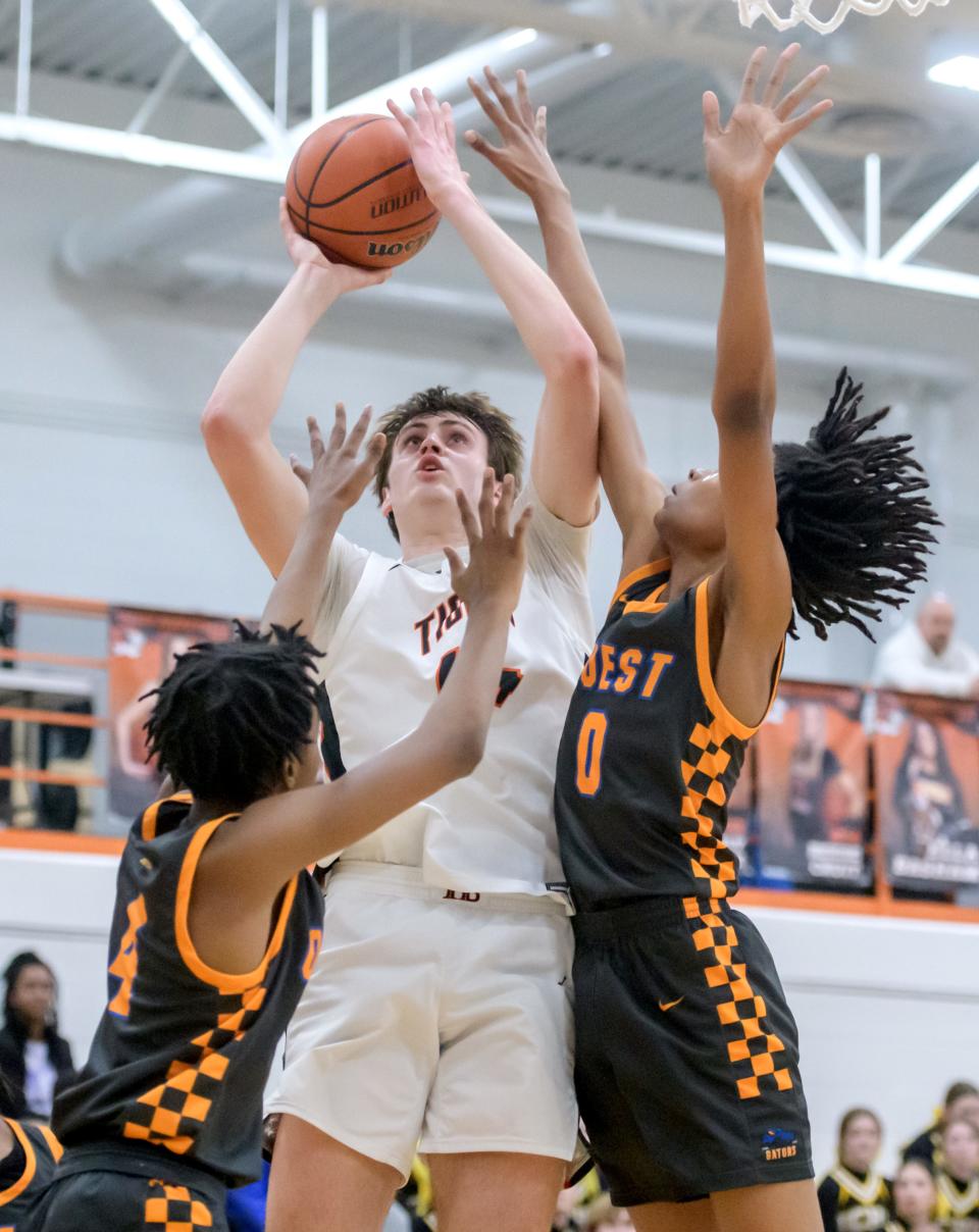 Peoria Quest's Marcus Triplet, left, and Keesian Davies, right, defend against Illini Bluffs' Hank Alvey in the first half of their Class 1A boys basketball regional semifinal Wednesday, Feb. 21, 2024 at Illini Bluffs High School in Glasford. The Tigers advanced to the final with a 65-43 win.