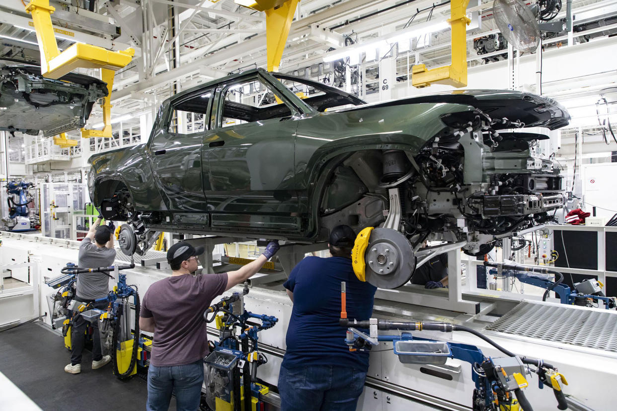 Workers lower an R1T truck body onto a chassis in the assembly line, April 11, 2022, at the Rivian electric vehicle plant in Normal, Illinois. (Brian Cassella/Chicago Tribune/Tribune News Service via Getty Images)