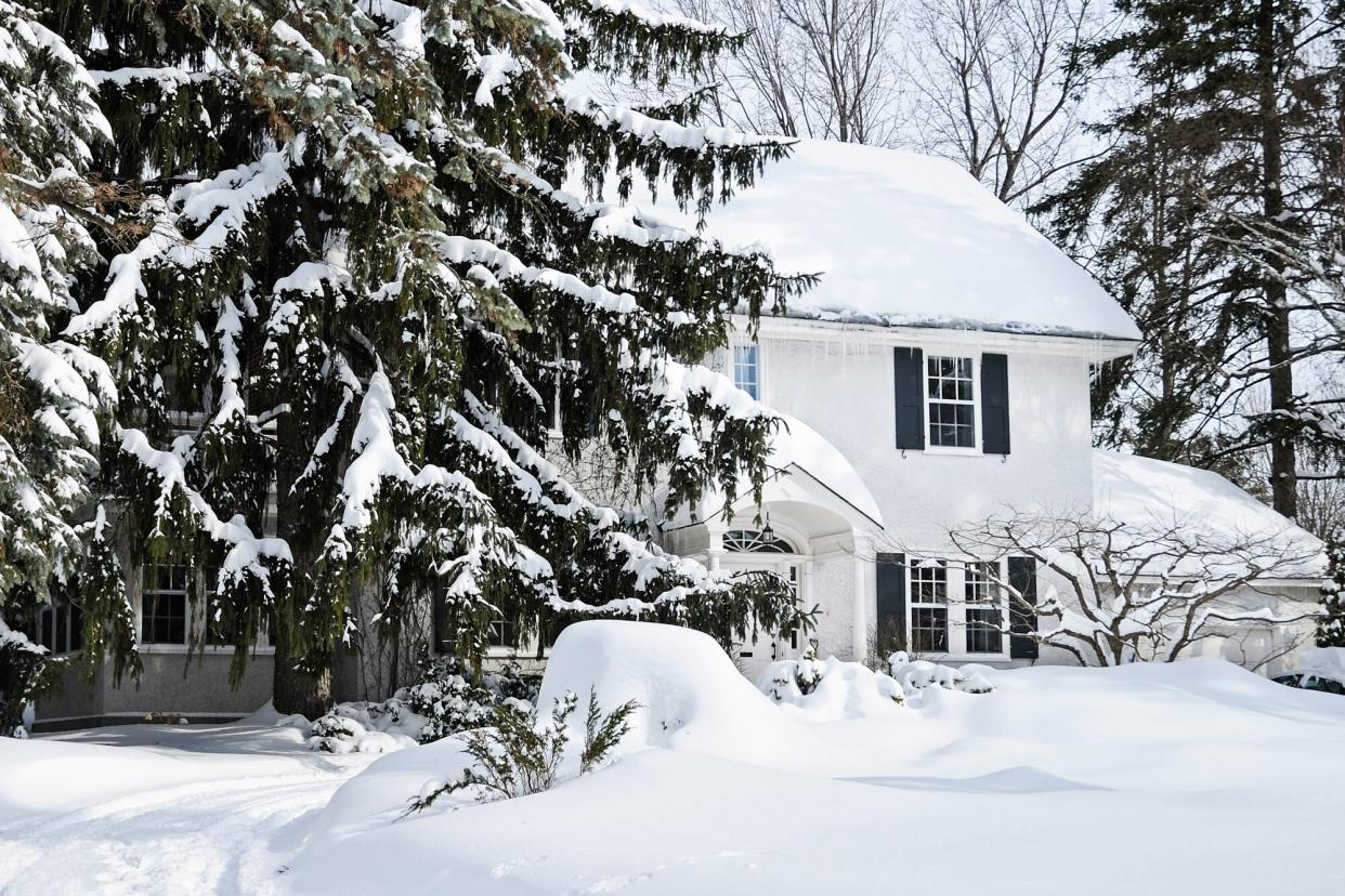 Snow covered house and fir trees