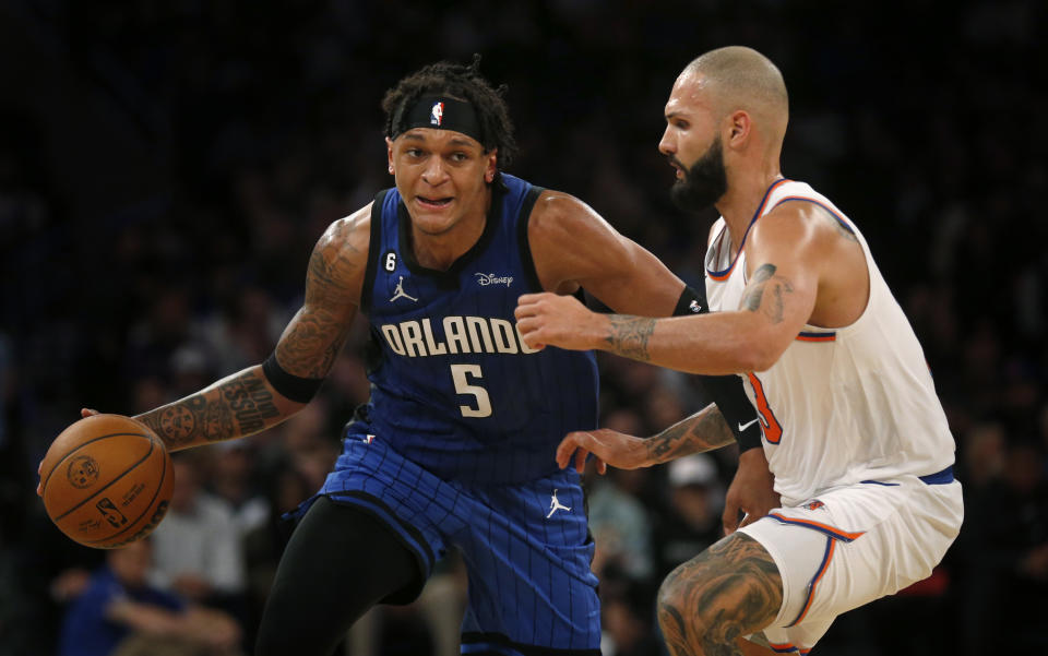 New York Knicks guard Evan Fournier, right, defends against Orlando Magic forward Paolo Banchero (5) during the first half of an NBA basketball game Monday, Oct. 24, 2022, in New York. (AP Photo/John Munson)