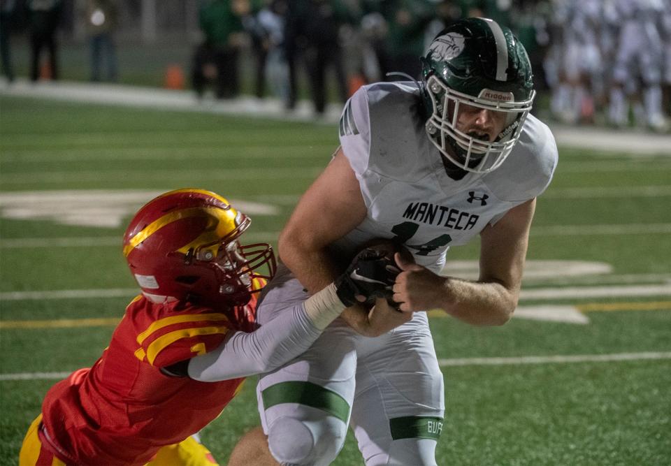 Manteca's Garrison Reis, right, scores a touchdown while Oakdale's Rocky Richardson tries to stop him during the Sac-Joaquin Section Division III championship game at St. Mary's High School in Stockton. Manteca won 35-28.