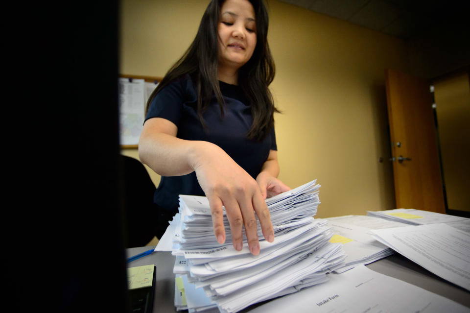 Kha Moua Vang takes paper applications at Portico HealthNet as the MNsure website became overloaded, Monday, March 31, 2014, in St. Paul, Minn. The call center for Minnesota's online health insurance marketplace strained Monday under a crush of people trying to beat the midnight Monday deadline for open enrollment, while residents lined up to take advantage of locations offering in-person help. (AP Photo/Star Tribune, Glen Stubbe)